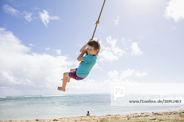 Boy swinging on beach