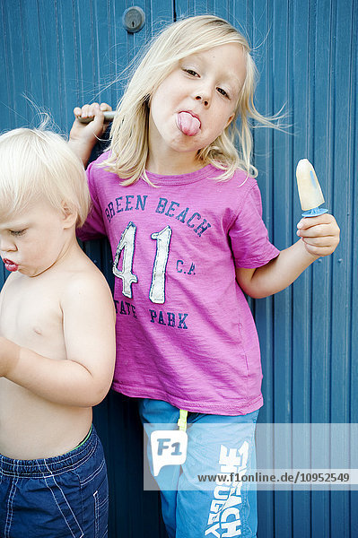 Mädchen streckt die Zunge heraus und hält Eiscreme