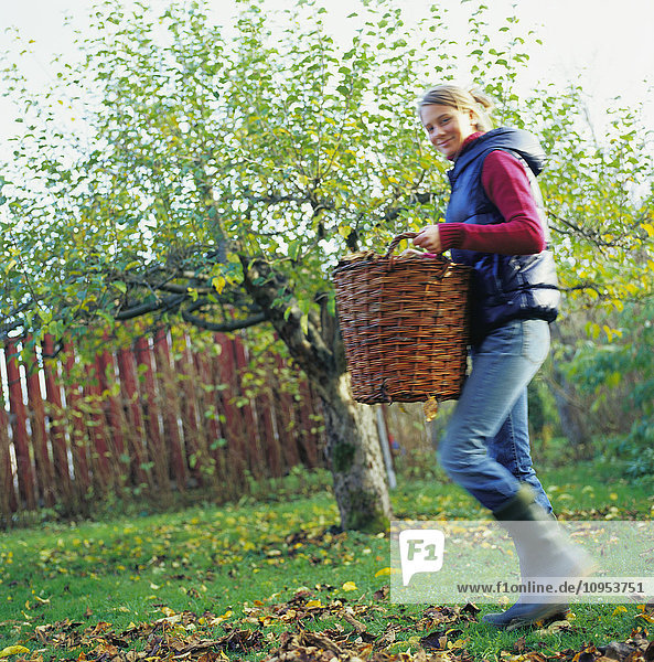 Woman with basket walking in the garden.