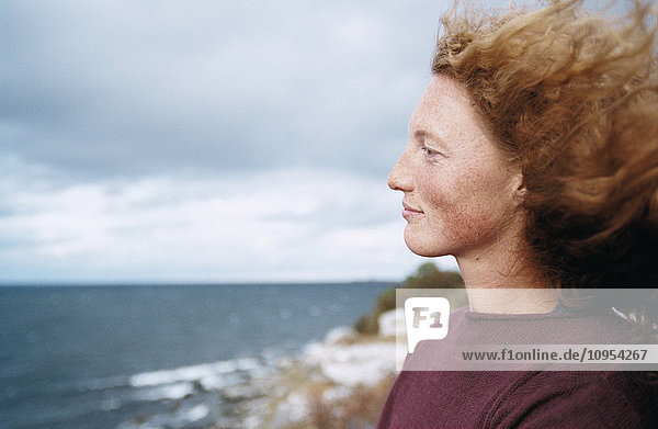 Redhead woman looking at sea
