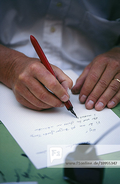 Die Hände einer Frau  die einen Brief schreibt.