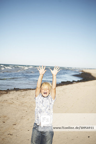 Ein glücklicher Junge an einem sonnigen Strand  Schweden.