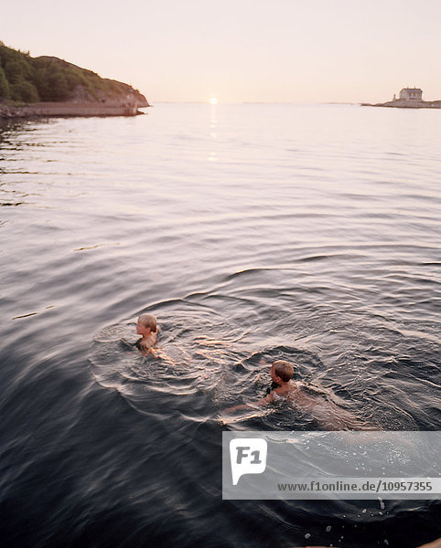 Two children going for a swim in the evening  Sweden.
