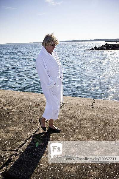 Woman in a bathrobe by the sea  Sweden.