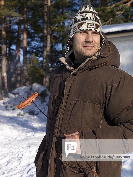 Man with grilling hot dogs outdoors  Sweden.