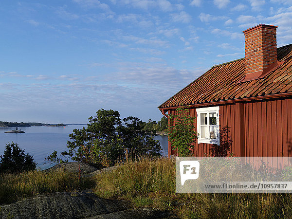Eine rote Hütte in den Schären von Stockholm  Schweden.