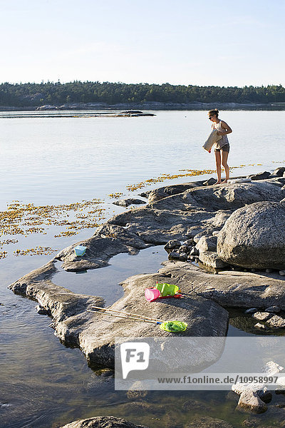 Frau auf einem Felsen am Meer  Schweden.