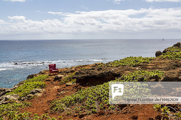 Ansicht eines roten gepolsterten Sessels  der auf einer Klippe steht; Poipu  Kauai  Hawaii  Vereinigte Staaten von Amerika'.