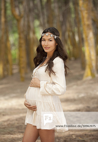 'A pregnant woman walking in the woods; Hawaii  United States of America'