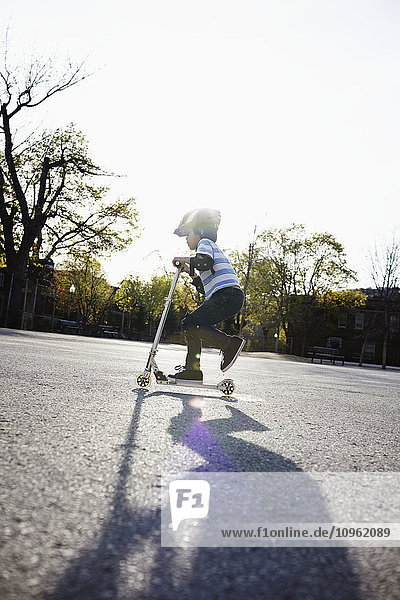 'Young boy riding a 2-wheeled scooter; Montreal  Quebec  Canada'