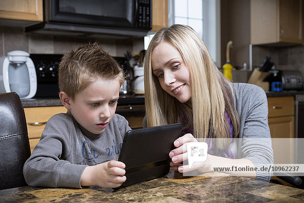 Behinderte Mutter hilft ihrem Sohn beim Lernen mit einem Tablet; Spruce Grove  Alberta  Kanada