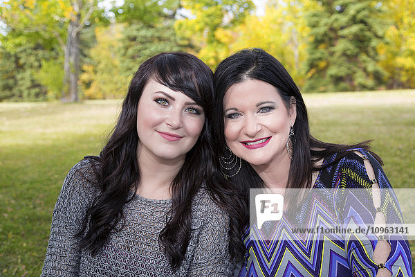 'Portrait of a mother and daughter spending quality time together outdoors in a city park in autumn; St. Albert  Alberta  Canada'