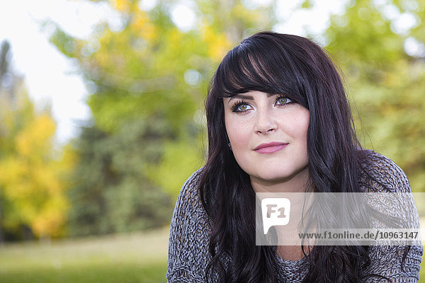 'Portrait of a beautiful young woman outdoors in a city park in autumn; St. Albert  Alberta  Canada'