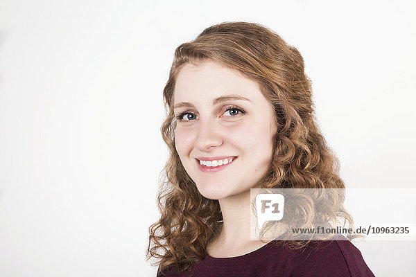 'Portrait of a young woman with blond curly hair on a white background; Alberta  Canada'