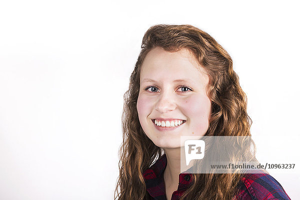'Portrait of a young woman with long  curly hair on a white background; Alberta  Canada'