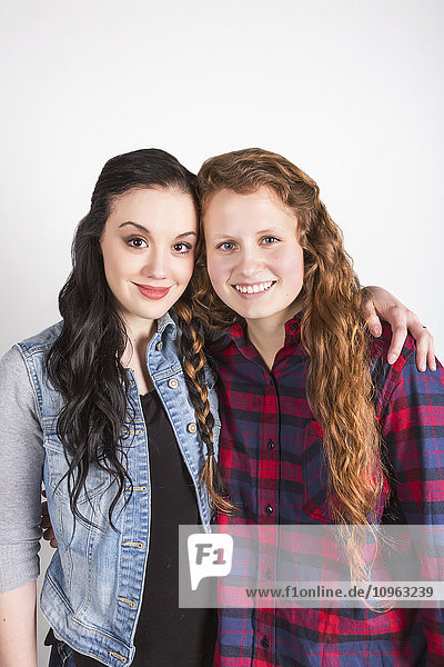 'Studio portrait of two young women with their hair braided together; Alberta  Canada'