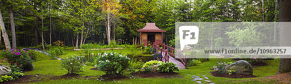 Landgarten mit roter Holzstruktur  Pflanzen und Bäumen; Knowlton  Quebec  Kanada'.