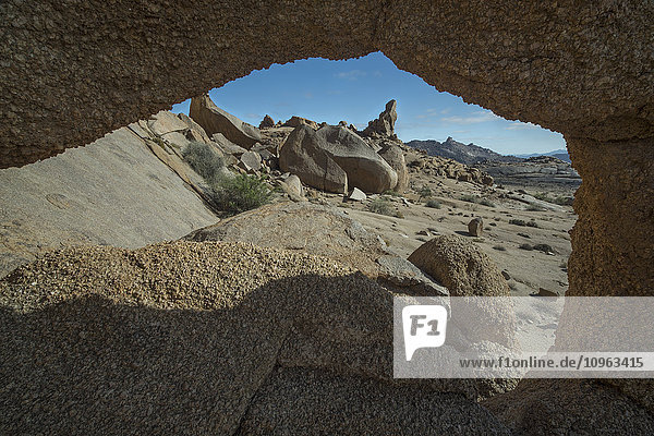Blick durch ein Loch in den Felsen auf die Landschaft des Richtersveld National Park; Südafrika'.
