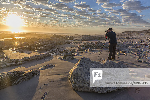 'Man standing taking photos at Marble Beach in Namakwaland National Park; South Africa'