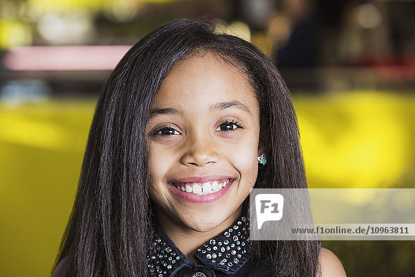'Young girl smiling for a portrait in a cafeteria at a shopping mall; St. Albert  Alberta  Canada'