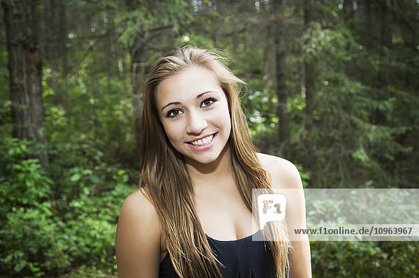 'Beautiful teenage girl posing for a picture while walking in a park; Edmonton  Alberta  Canada'