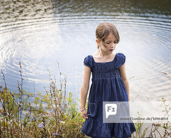 Porträt eines jungen Mädchens  das am Ufer steht und eine große Welle im Wasser sieht; Chilliwack  British Columbia  Kanada'.