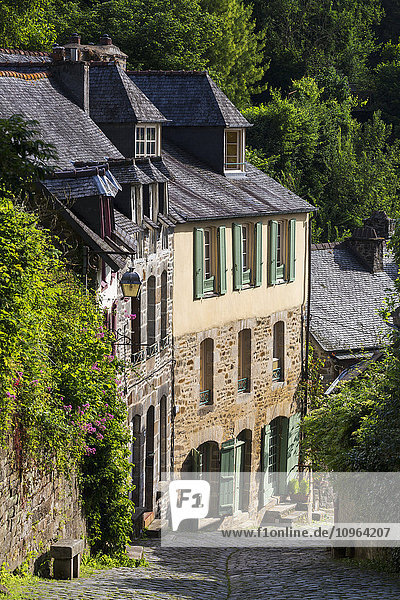 Alte Steinhäuser mit grünen Fensterläden an einer Kopfsteinpflasterstraße; Dinan  Bretagne  Frankreich'.