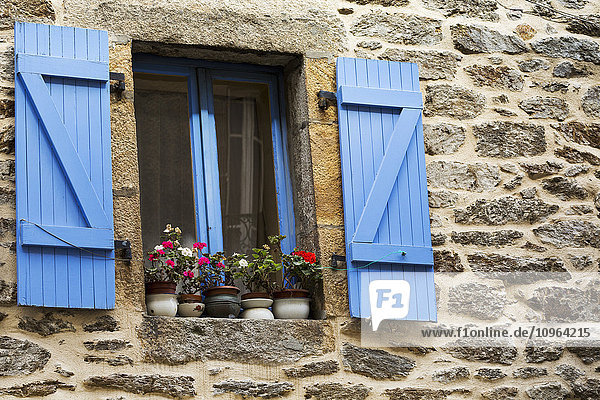 Nahaufnahme von bunt bemalten blauen Fensterläden und Fensterrahmen an einem Steinhaus mit Blumentöpfen auf der Fensterbank; Brest  Bretagne  Frankreich'.