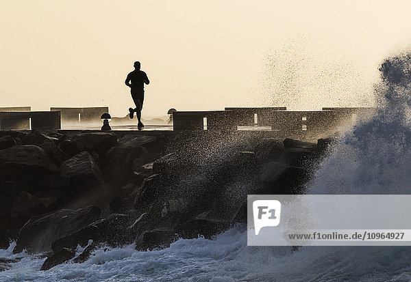 'Silhouette of a man running along the coast; La Isla  Tarifa  Cadiz  Andalusia  Spain'