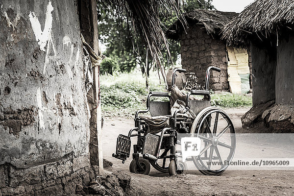 Rollstuhl vor einem Haus; Uganda'.