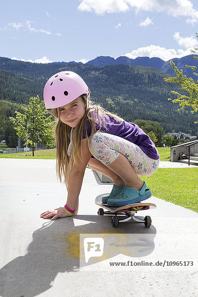 Junges Mädchen auf einem Skateboard mit einem rosa Helm; Salmon Arm  British Columbia  Kanada'.