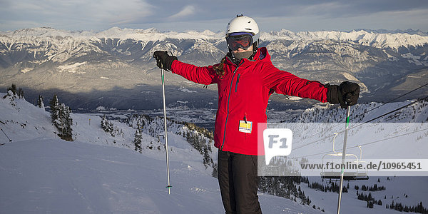 'A skier on a mountain top with a view of the Canadian Rocky mountains  Banff national park; Alberta  Canada'