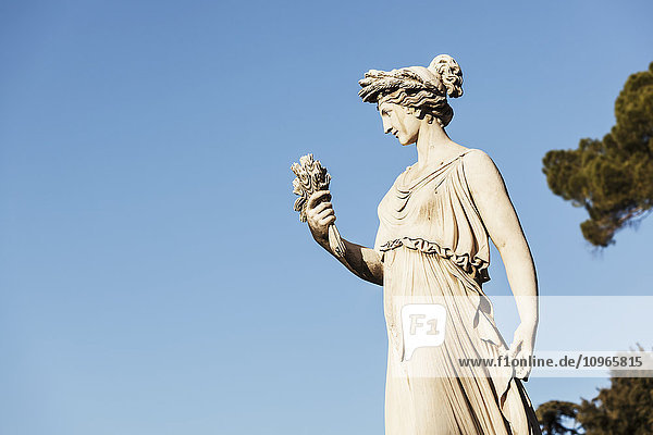 Statue einer weiblichen Figur vor blauem Himmel; Rom  Italien'.