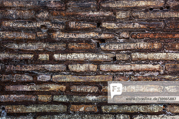 'Names defacing a stone wall  Colosseum; Rome  Italy'