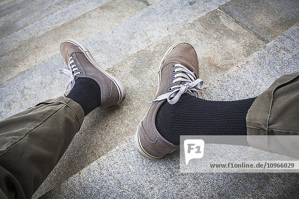 Beine und Füße eines Mannes auf den Stufen eines Betongebäudes; Hartford  Connecticut  Vereinigte Staaten von Amerika'.