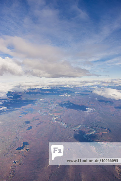 'Aerial view of patchy clouds above a tundra landscape  a river cutting through the foreground; Alaska  United States of America'