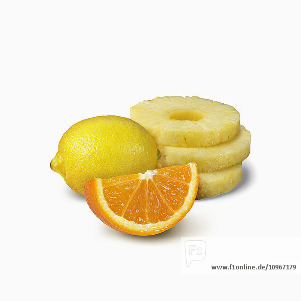 'Pineapple slices  orange wedge and a lemon on a white background; Toronto  Ontario  Canada'