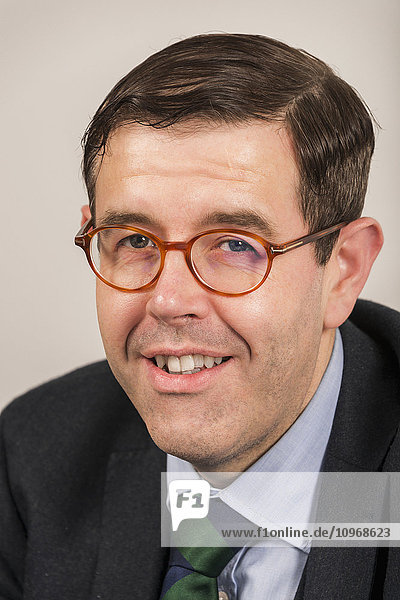 'Portrait of a businessman wearing eyeglasses and a suit and tie; England'