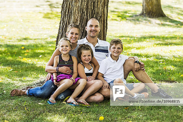 Eine Familie posiert für ein Familienporträt in einem Park; Edmonton,  Alberta,  Kanada'.