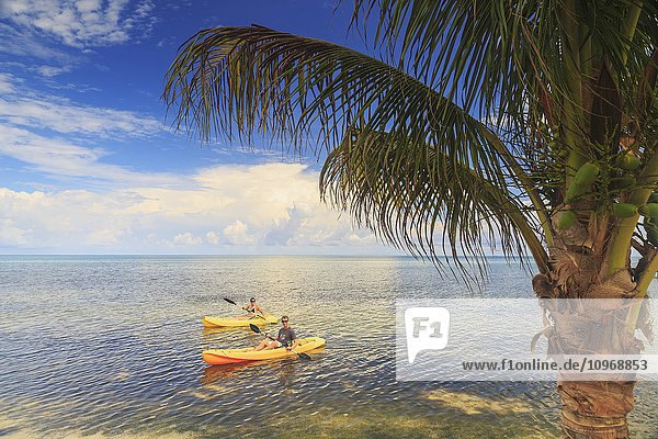 Ein Paar benutzt Kajaks im Saint Georges Caye Resort; Belize City  Belize'.