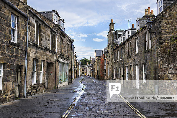 Kopfsteinpflasterweg in der Mitte einer Straße  die zwischen Häuserreihen verläuft; St. Andrews  Fife  Schottland
