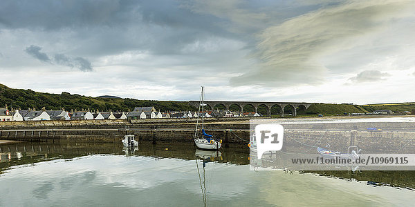 Boote  die im ruhigen Hafen der Nordsee vor Anker liegen  mit Häusern im Hintergrund; Cullen  Moray  Schottland