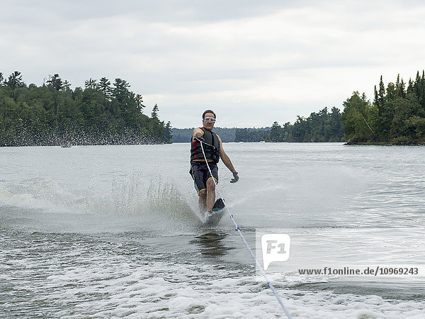 'A man wake boarding on a lake; Ontario  Canada'