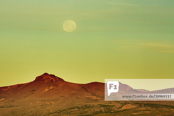 Der Mond geht über einer gelben Wüstenlandschaft auf; Bariloche  Argentinien'.