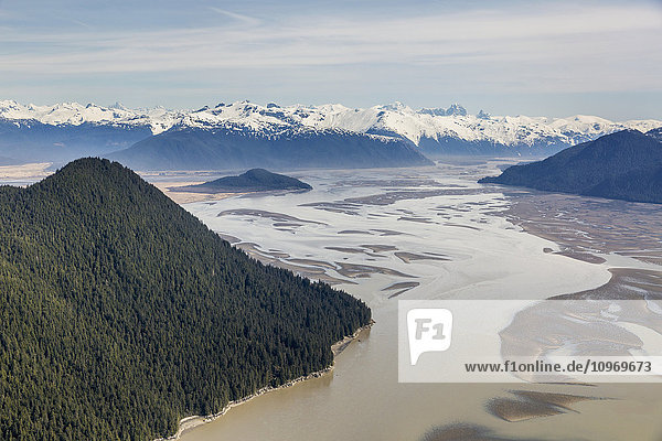 'Aerial view of Woronkofski Island along the Stikine River Delta  low tide revealing mud flats below the snow capped peaks in the background; Wrangell  Alaska  United States of America'