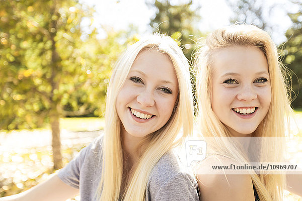 Porträt von zwei Schwestern in einem Stadtpark im Herbst; Edmonton  Alberta  Kanada