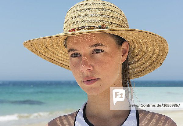 'Portrait of a young woman on the beach wearing a sunhat; Tarifa  Cadiz  Andalusia  Spain'
