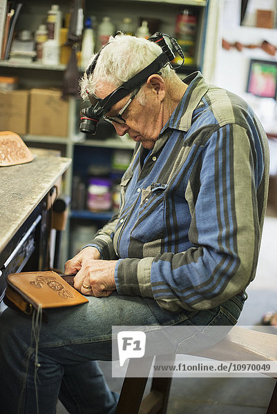 'A mature man working on a leather piece; Waimea  Island of Hawaii  Hawaii  United States of America'