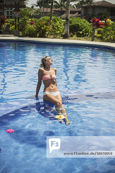 Frau in einer Ferienanlage am Pool; Insel Hawaii  Hawaii  Vereinigte Staaten von Amerika'.