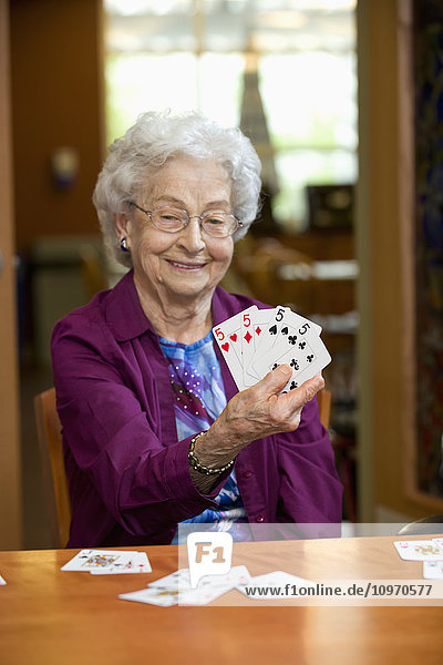 Eine ältere Frau zeigt die Karten in ihrer Hand; Edmonton  Alberta  Kanada'.